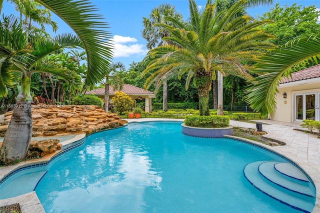 outdoor pool featuring a patio area and french doors