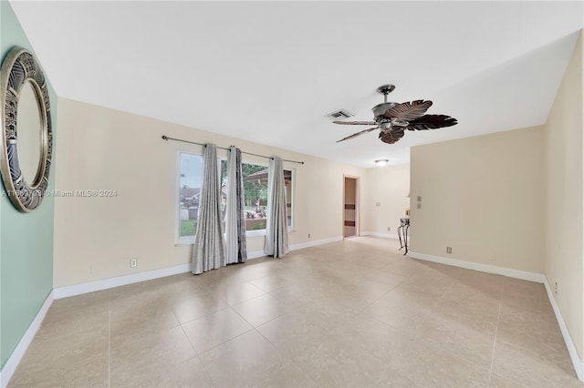 tiled spare room featuring ceiling fan