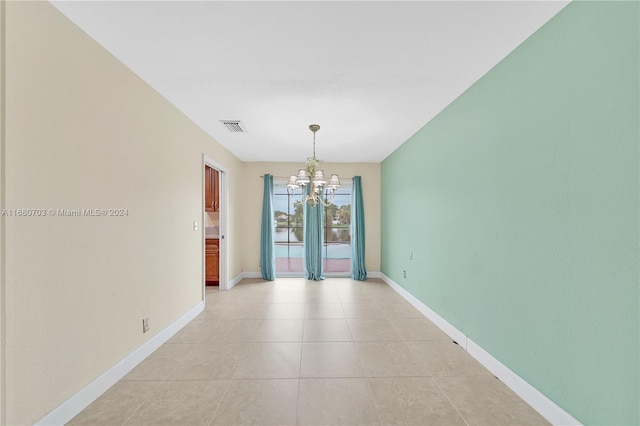 unfurnished dining area with a notable chandelier and light tile patterned floors