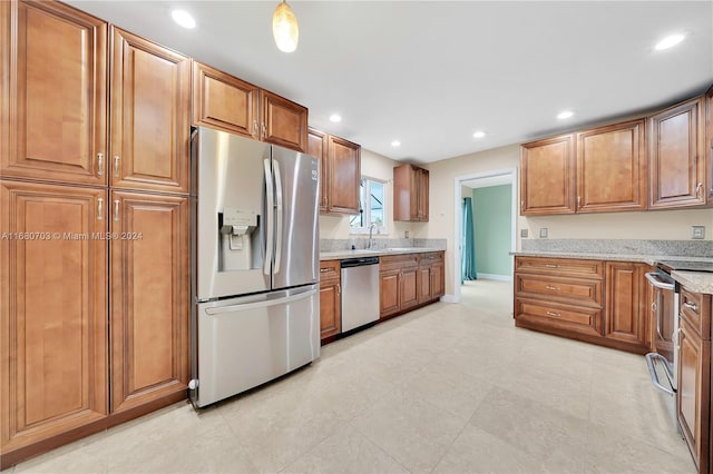 kitchen featuring light stone counters, appliances with stainless steel finishes, and sink