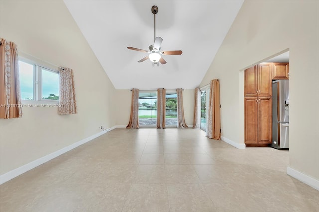 empty room with ceiling fan, high vaulted ceiling, and light tile patterned floors