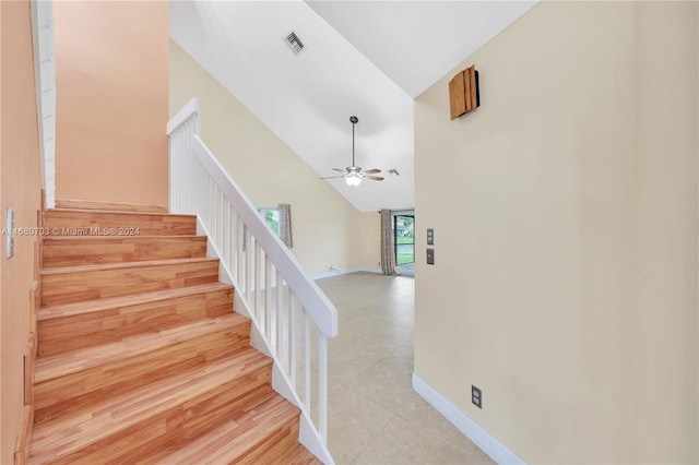 stairs featuring ceiling fan, high vaulted ceiling, and wood-type flooring