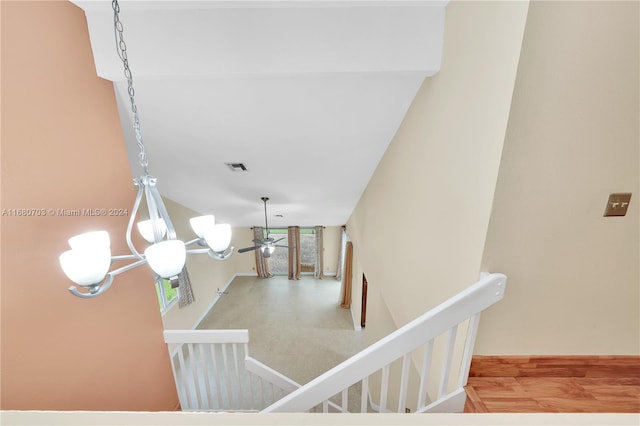 staircase with wood-type flooring and a chandelier