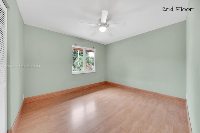 empty room with ceiling fan and light hardwood / wood-style flooring