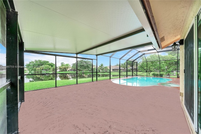 view of swimming pool with a patio, a lanai, a lawn, and a water view