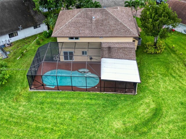 view of pool featuring a patio, a lawn, and glass enclosure