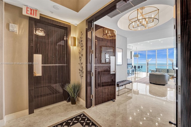 corridor featuring a water view and a notable chandelier