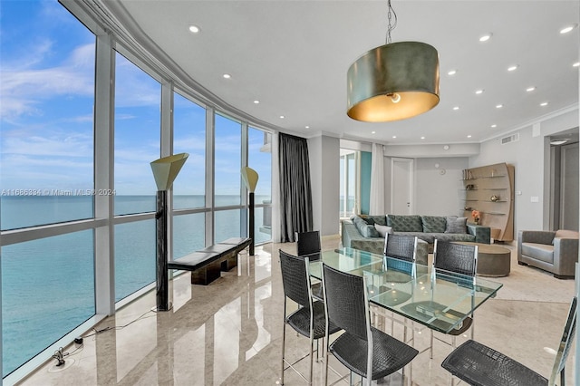 dining space with crown molding, a wall of windows, and a water view