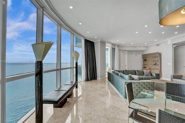 living room with a water view, ornamental molding, and expansive windows