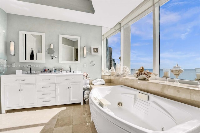 bathroom featuring vanity, a water view, and a bath