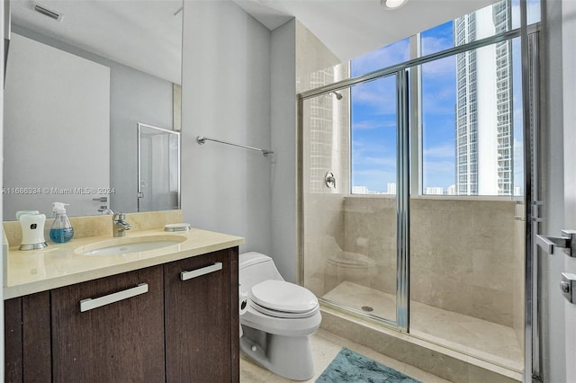 bathroom featuring a shower with door, vanity, toilet, and tile patterned floors