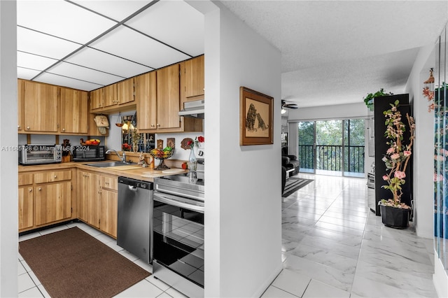 kitchen featuring sink, stainless steel appliances, a textured ceiling, and ceiling fan