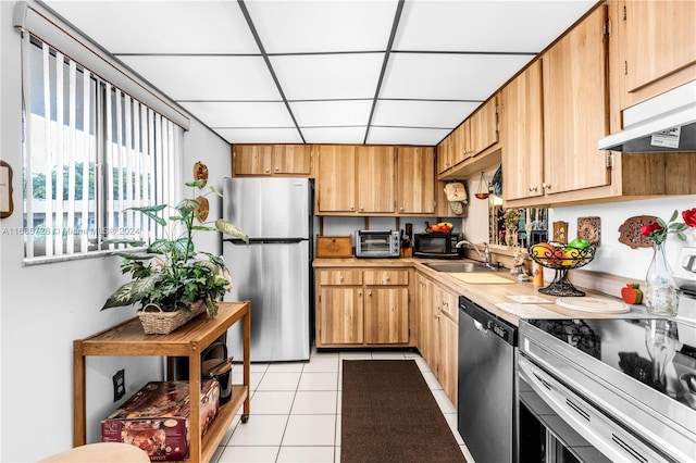 kitchen featuring sink, light tile patterned flooring, appliances with stainless steel finishes, and a drop ceiling