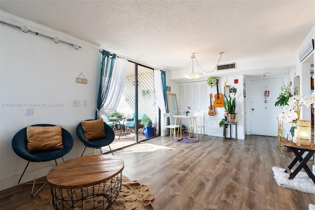 sitting room with floor to ceiling windows, a textured ceiling, and hardwood / wood-style floors