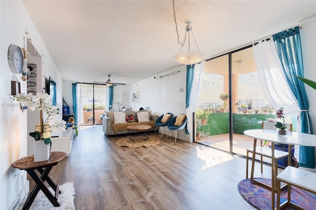 living area with a textured ceiling, wood finished floors, and ceiling fan