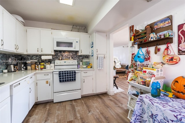 kitchen featuring light wood finished floors, white appliances, decorative backsplash, and light countertops