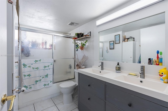 full bathroom with a sink, tile patterned flooring, visible vents, and enclosed tub / shower combo
