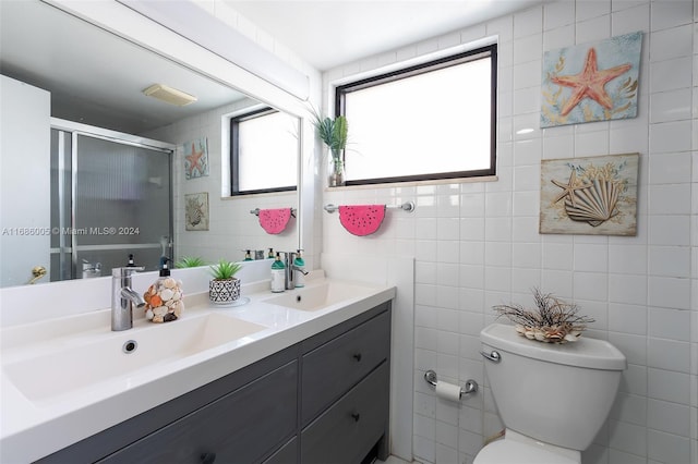 full bath featuring a sink, double vanity, toilet, and a stall shower