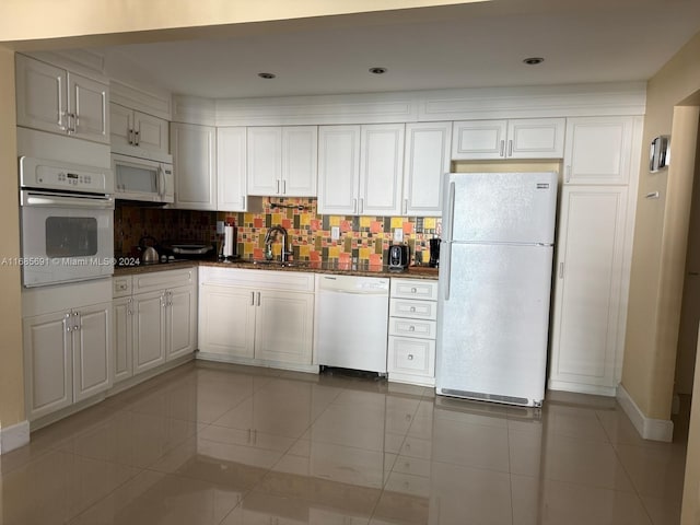 kitchen with white appliances, sink, white cabinets, decorative backsplash, and light tile patterned floors