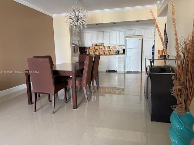 tiled dining room featuring crown molding and a chandelier