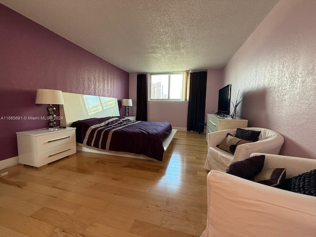 bedroom with a textured ceiling and light wood-type flooring