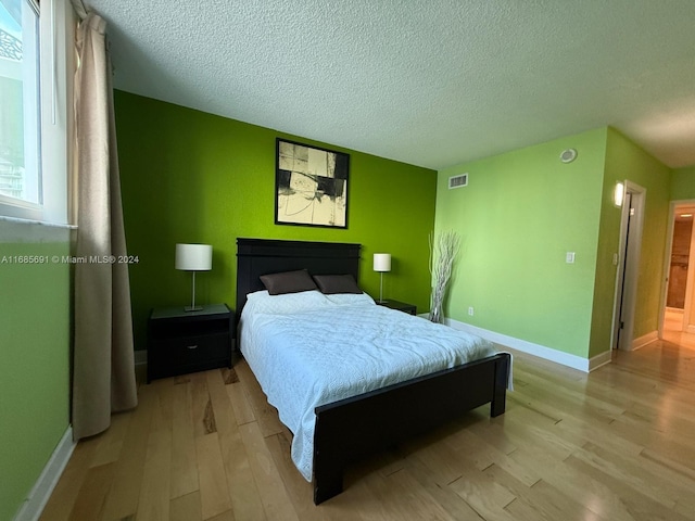 bedroom featuring a textured ceiling and light wood-type flooring