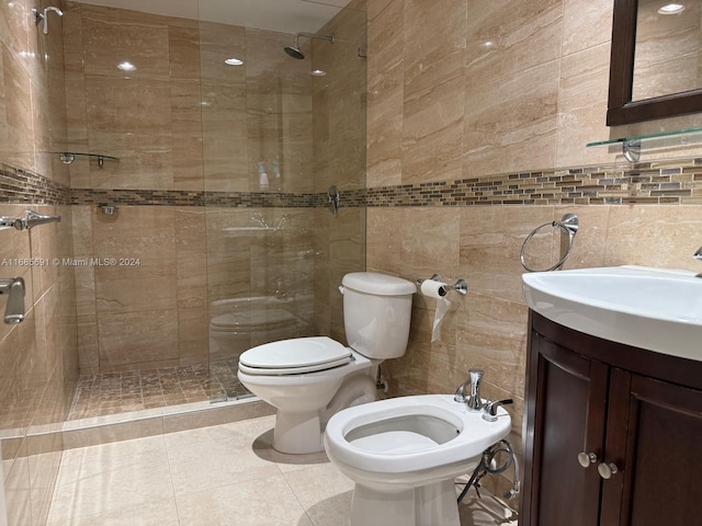 bathroom featuring vanity, toilet, tile walls, and a bidet