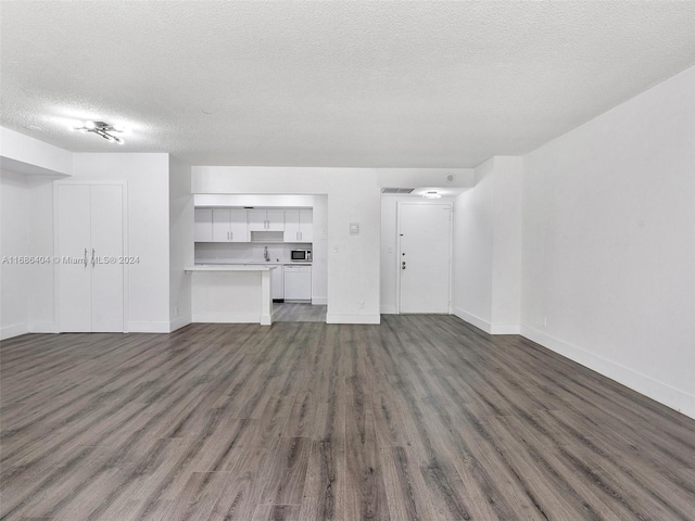 unfurnished living room with dark hardwood / wood-style flooring, sink, and a textured ceiling