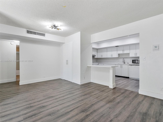 unfurnished living room with dark hardwood / wood-style flooring, a textured ceiling, and sink