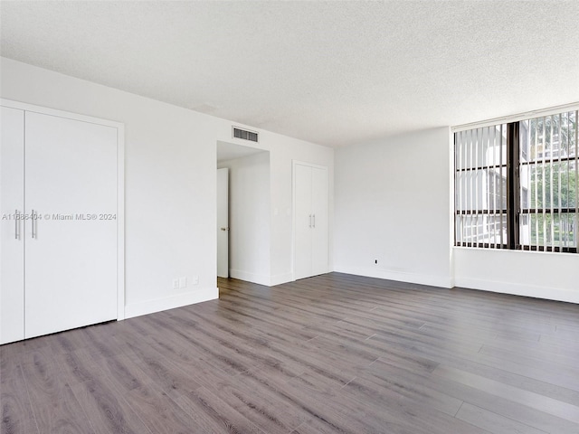 unfurnished room with hardwood / wood-style floors and a textured ceiling