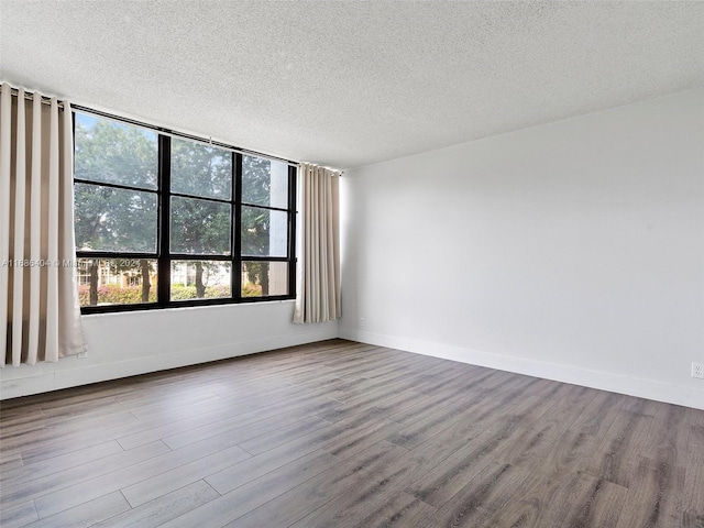 spare room with hardwood / wood-style flooring and a textured ceiling