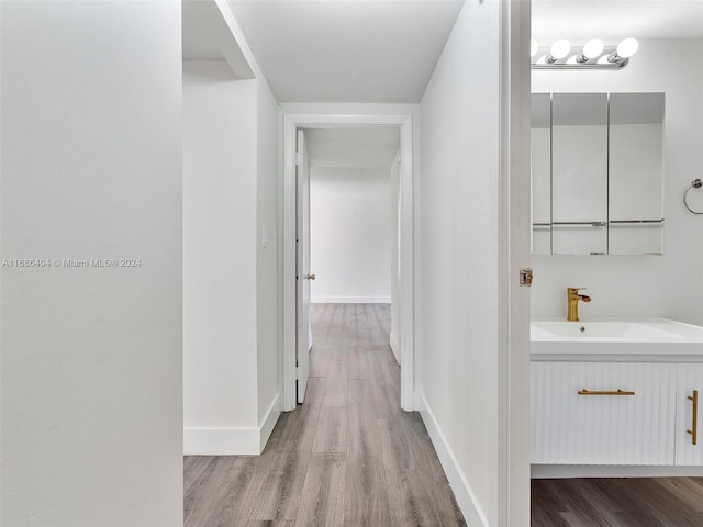 hall featuring light hardwood / wood-style floors and sink