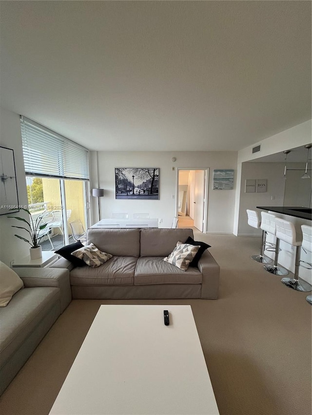 living area featuring a bar, visible vents, and carpet flooring