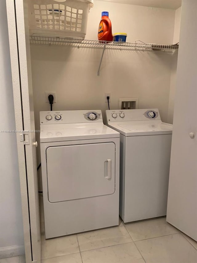 washroom featuring laundry area, light tile patterned flooring, and washing machine and dryer