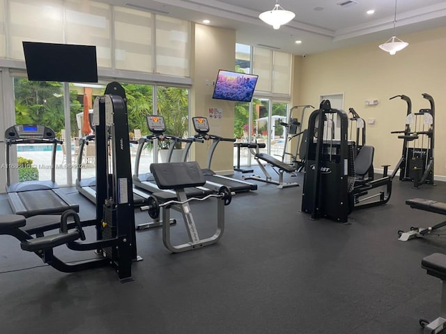 workout area featuring crown molding, recessed lighting, visible vents, a towering ceiling, and baseboards