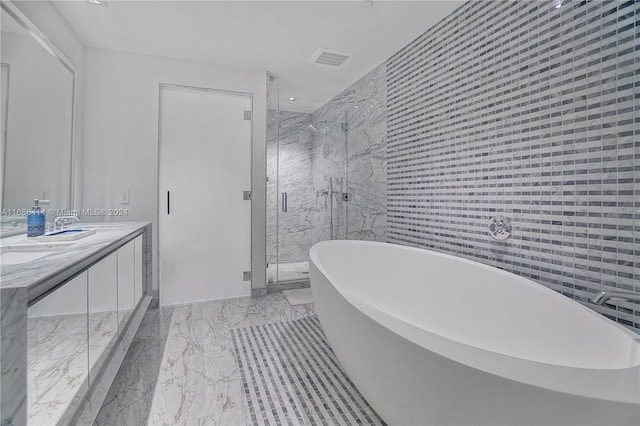 bathroom featuring shower with separate bathtub, vanity, and tile walls