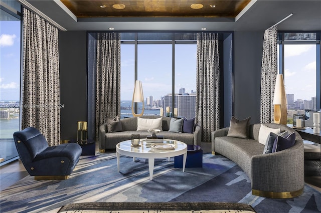 living room with a tray ceiling and floor to ceiling windows