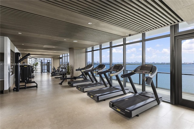 gym with a water view and expansive windows