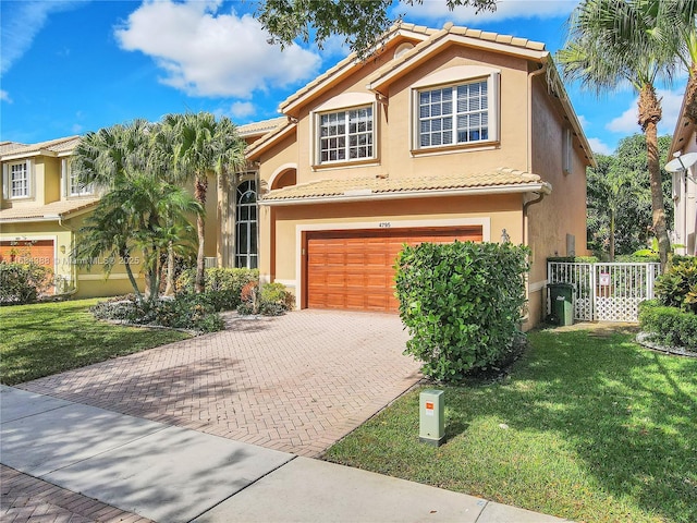 4795 S Classical Blvd, Delray Beach, FL 33445 - mediterranean / spanish-style house featuring a front lawn, a tiled roof, stucco siding, and a garage