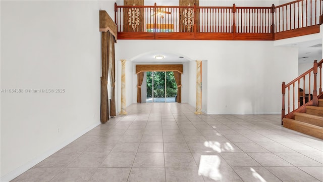 4795 S Classical Blvd, Delray Beach, FL 33445 - unfurnished room with tile patterned flooring, a towering ceiling, arched walkways, and stairs