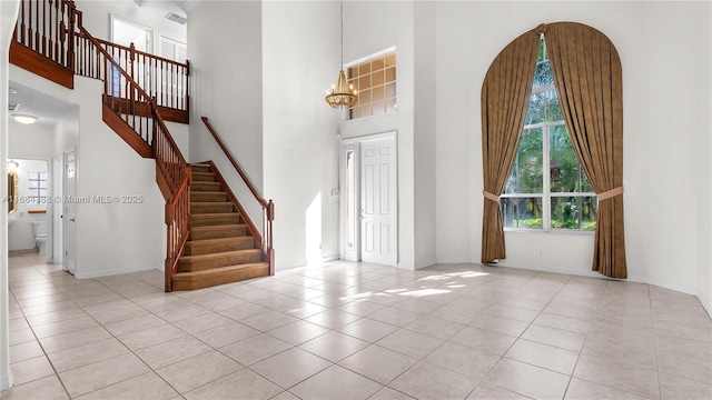 4795 S Classical Blvd, Delray Beach, FL 33445 - tiled foyer with stairway, baseboards, a towering ceiling, arched walkways, and a chandelier