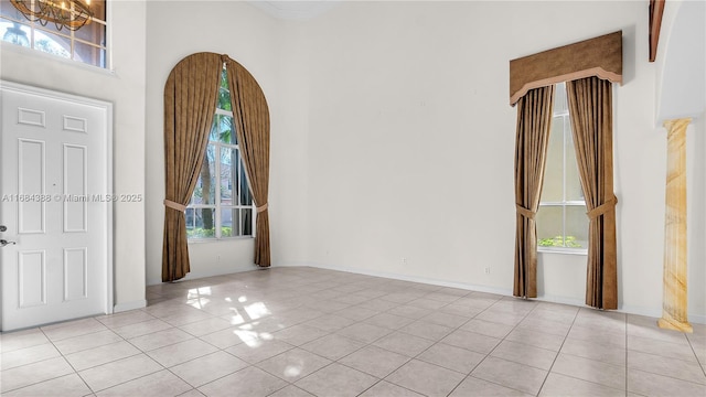 4795 S Classical Blvd, Delray Beach, FL 33445 - foyer entrance featuring baseboards, a notable chandelier, tile patterned flooring, and a high ceiling