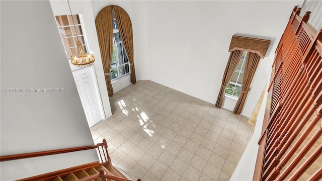4795 S Classical Blvd, Delray Beach, FL 33445 - interior space with light tile patterned floors, a notable chandelier, a towering ceiling, and baseboards
