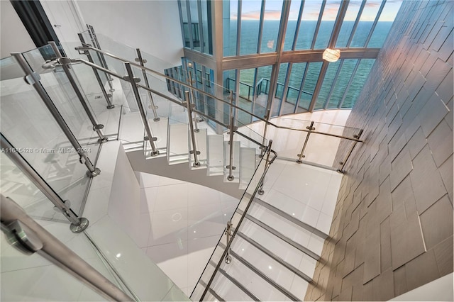 staircase with a wealth of natural light and a water view