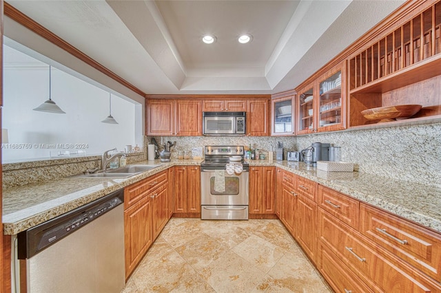 kitchen with decorative backsplash, hanging light fixtures, a tray ceiling, sink, and appliances with stainless steel finishes