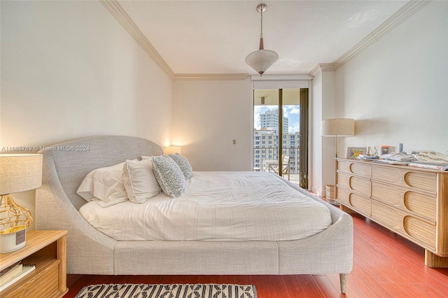 bedroom with ornamental molding, hardwood / wood-style floors, and access to exterior