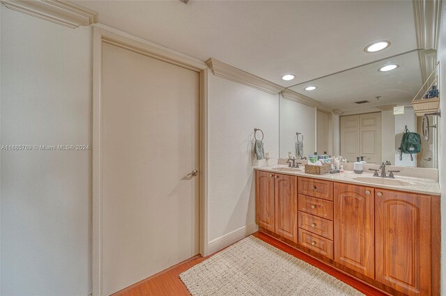 bathroom with vanity, wood-type flooring, and ornamental molding