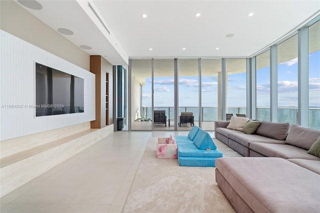 tiled living room with expansive windows and a water view