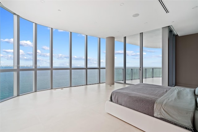 bedroom featuring a water view, expansive windows, and multiple windows