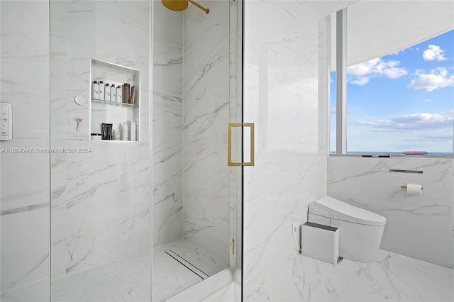 bathroom featuring a shower with door and toilet